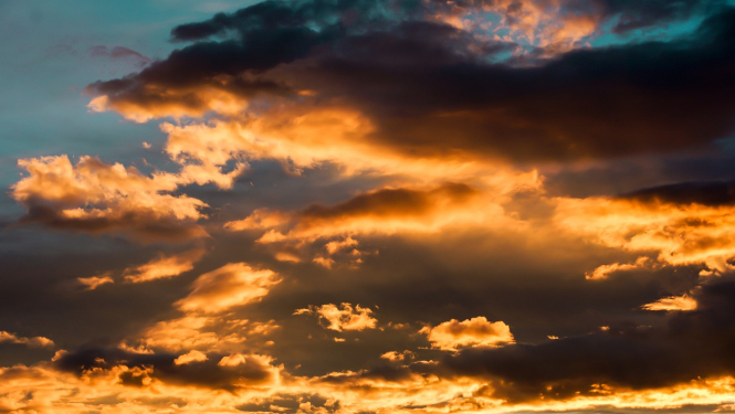 Debesis ar mākoņiem, aiz kuriem spīd cauri saulriets