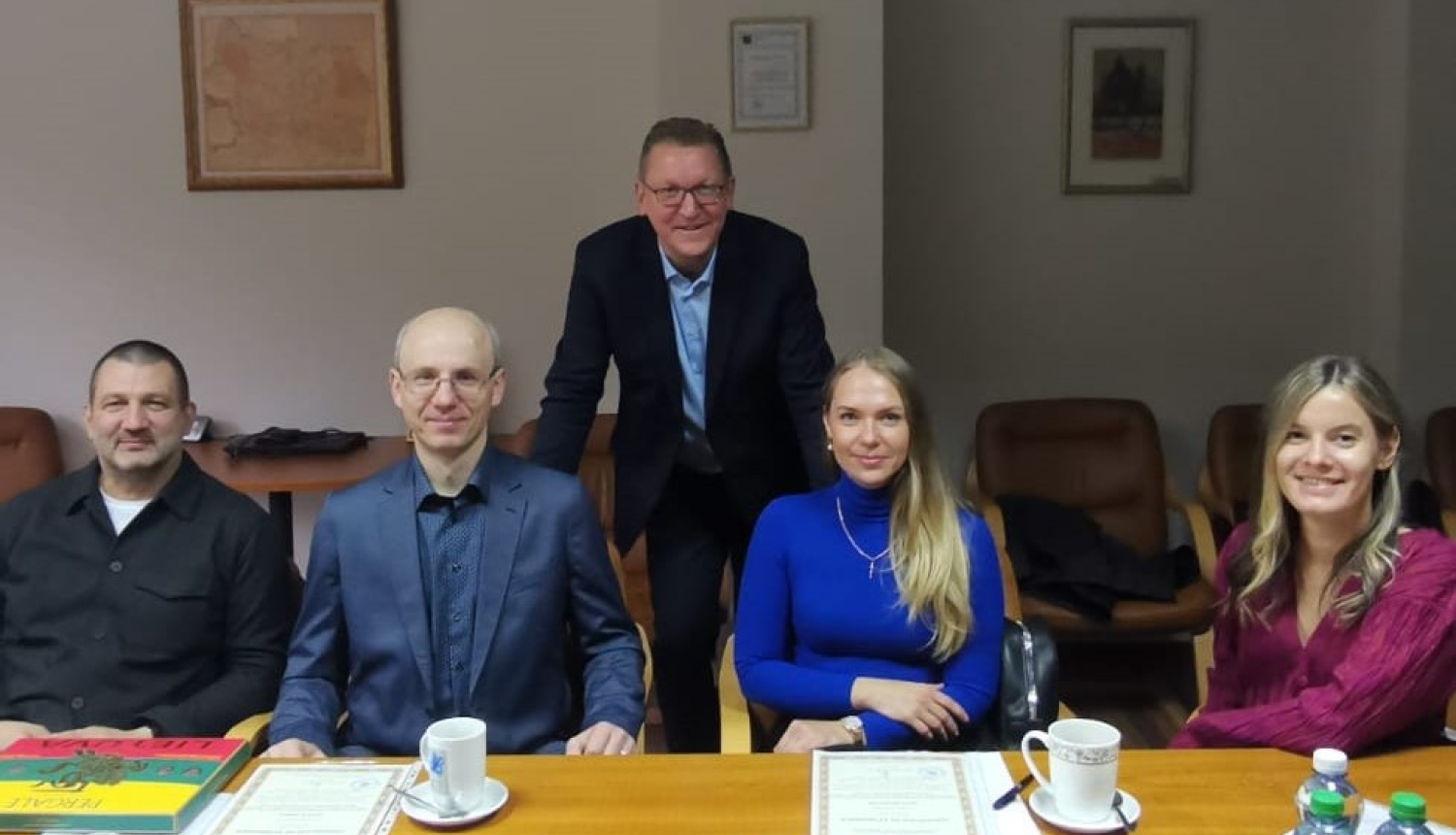 Tiesu medicīnas eksperti sēž pie sanāksmju galda